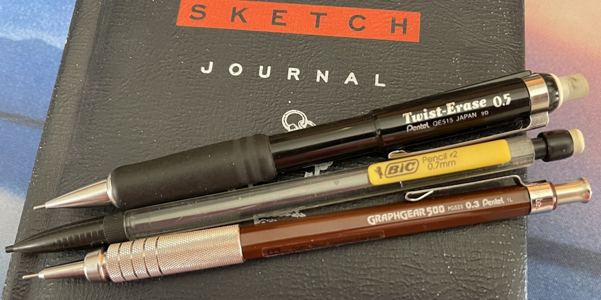Three of the best mechanical pencils laying on a sketch journal